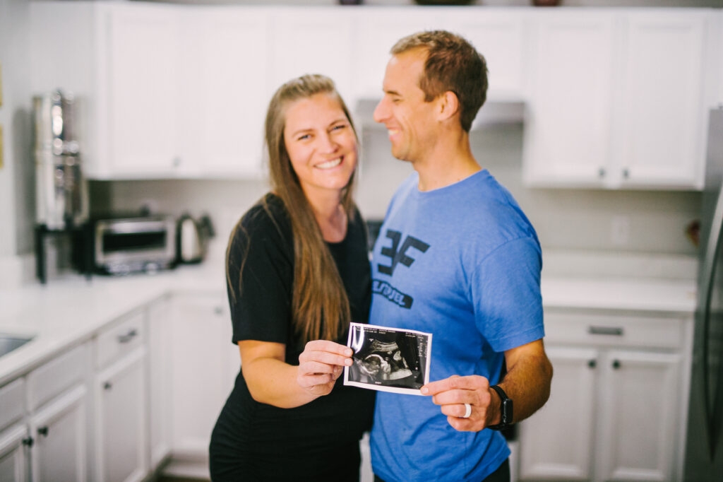 Pregnant woman and man holding ultrasound picture